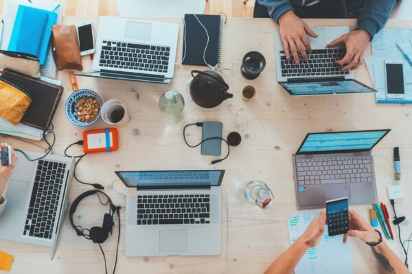 people sitting down near people sitting down near table with assorted laptop computers